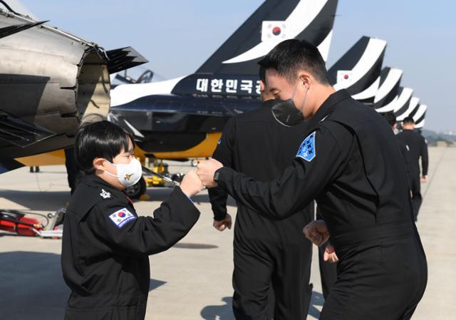 공군 특수비행팀 블랙이글스가 22일 ‘서울ADEX 2021’이 진행 중인 경기 성남시 서울공항에서 희소소아암으로 투병 중인 최윤수(왼쪽)군을 위한 특별 이벤트를 마련했다. 최군과 블랙이글스 조종사 박용하 대위가 주먹 인사를 하고 있다. 공군 제공