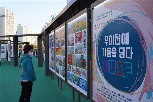 한 주민이 지난 20일 서울 강북구 우이천 번창교 하부 야외공간에 마련된 미술작품 전시를 감상하고 있다.강북구 제공