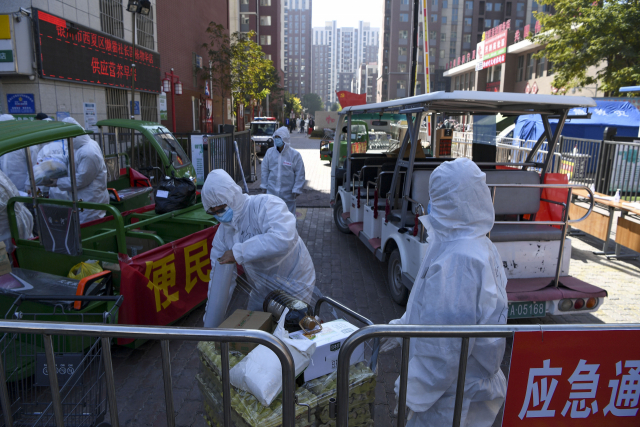 코로자19가 발생한 중국 닝샤자치구 인촨시의 한 구역이 21일 봉쇄된 가운데 방역관계자들이 생필품을 배급하고 있다. /신화연합뉴스