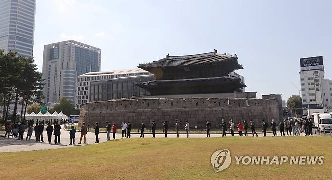 검사행렬 (서울=연합뉴스) 서명곤 기자 = 22일 오후 서울 종로구 흥인지문 앞에 설치된 찾아가는 임시선별진료소에서 인근 시장 상인과 시민 등이 코로나19 선별검사를 받기 위해 순서를 기다리고 있다. 2021.10.22 seephoto@yna.co.kr