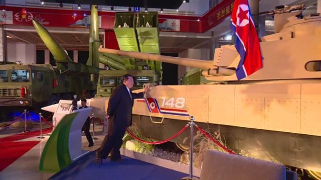 김정은 북한 국무위원장이 지난 12일 평야 3대혁명전시관에서 열린 국방발전전람회 '자위-2021' 전시장에서 최신형 탱크를 직접 만져보고 있다. 평양=조선중앙통신 연합뉴스
