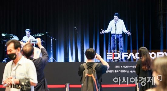 최근 서울 강남구 코엑스에서 열린 '제3회 4차산업혁명페스티벌'에서 관람객들이 홀로그램으로 재현된 故 김현식 의 공연을 보고 있다./강진형 기자aymsdream@