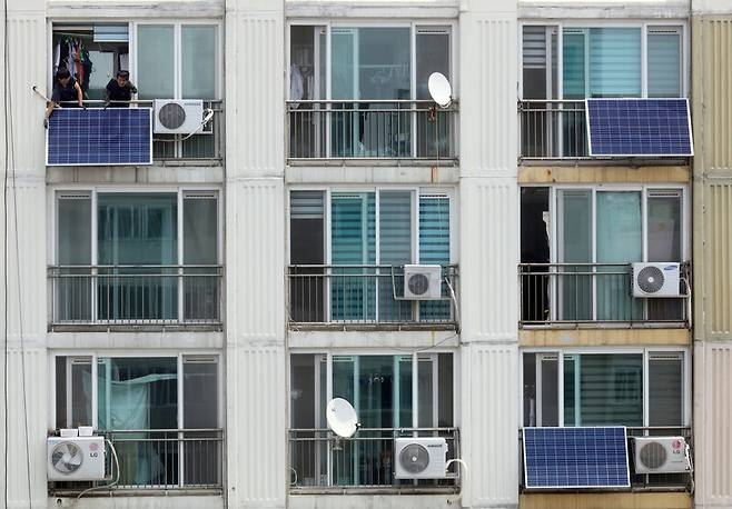 2017년 6월20일 서울 시내 한 아파트에서 태양광발전설비 업체가 베란다에 태양광 모듈을 설치하고 있다. 연합뉴스
