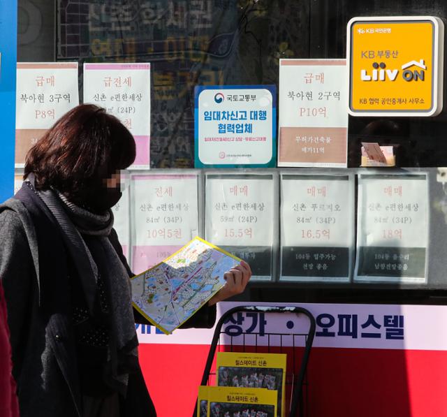 서울 서대문구의 한 부동산중개업소에 게시된 매물 안내문 앞으로 시민이 지도를 보며 지나가고 있다. 연합뉴스