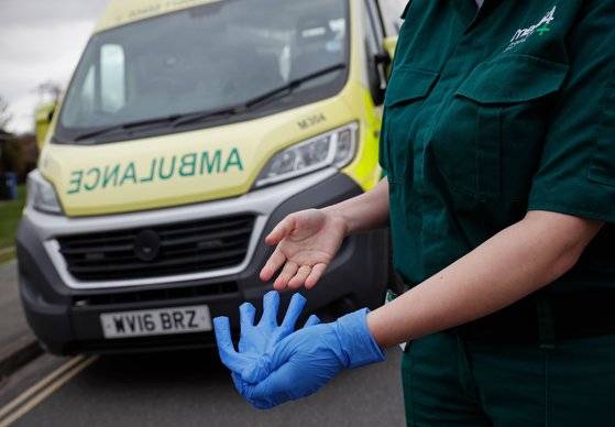 영국의 한 의료진이 앰뷸런스에서 환자를 검진한 뒤 니트릴 장갑을 벗고 있다. 연합뉴스