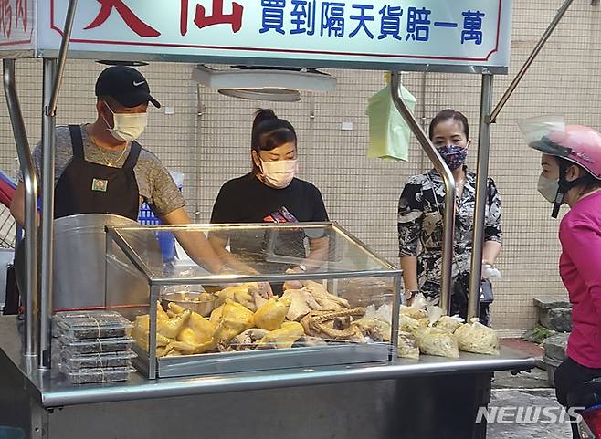 [타이베이=AP/뉴시스] 대만 수도 타이베이에서 19일 코로나19 예방을 위해 마스크를 착용한 시민들이 노점을 찾아와 먹을거리를 사고 있다. 2021.10.22