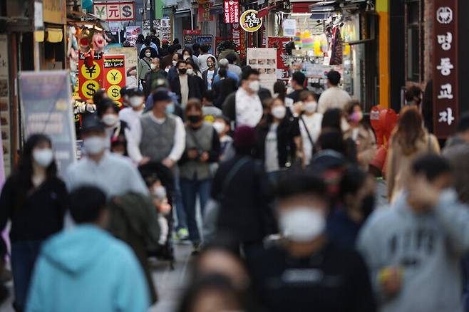 People enjoy a day out in the streets of Myeongdong in Seoul on Sunday, one day after South Korea hit a 70% vaccination completion rate — a key milestone for the gradual transition to normal life. (Yonhap News)
