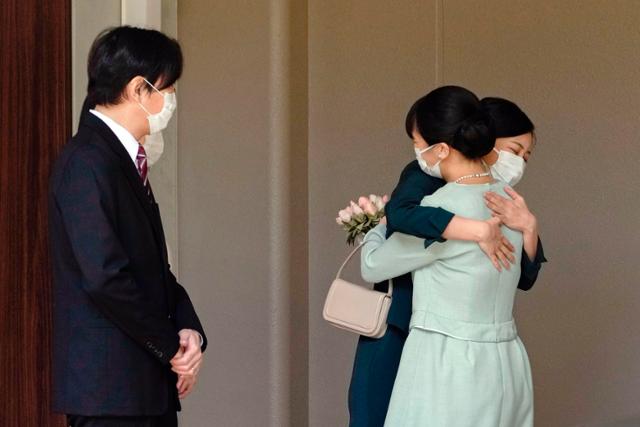 나루히토 일왕의 조카 마코(오른쪽) 공주가 26일 일본 도쿄에 있는 왕실 소유의 아카사카 어용지를 떠나며 부모인 아키시노노미야 왕세제 부부가 지켜보는 동안 자매인 가코 공주와 작별의 포옹을 나누고 있다. 마코 공주는 그의 일반인 남자 친구 고무로 게이와 결혼식 없이 혼인해 미국에서 신혼생활을 시작한다. 도쿄=AP 뉴시스