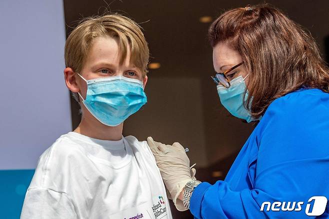 미국 코네티컷주 하트퍼드 코로나19 백신 접종소에서 2021년 5월 13일 한 13세 아동이 화이자 백신을 맞고 있다. © AFP=뉴스1