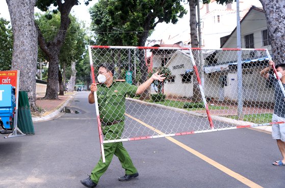 지난 9월 30일 베트남 경찰이 붕따우 지역에서 바리케이드를 제거하고 있다. 베트남은 거의 3개월간 엄격한 이동제한 정책을 실시했다. 사진 AP=연합뉴스