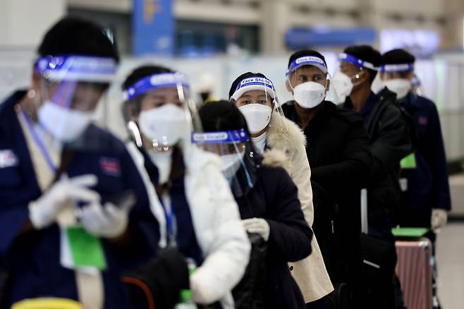 2021년 11월 30일 오전 인천국제공항을 통해 입국한 외국인들이 이동에 앞서 페이스쉴드와 장갑을 착용하고 있다. /연합뉴스
