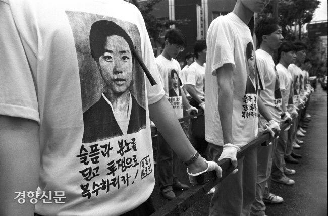 1991년 6월12일 김귀정 열사 장례식에서 열사의 영정이 새겨진 티셔츠를 입고 인간띠를 만든 대학생들의 모습. 경향신문 자료사진