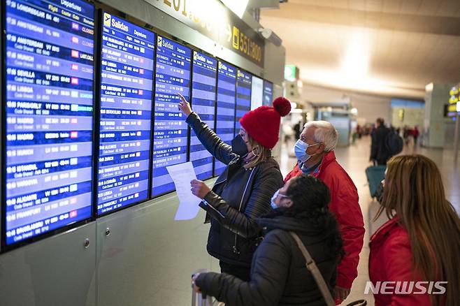[바르셀로나=AP/뉴시스]스페인 바르셀로나 공항에서 여행객들이 항공기 운항 정보를 확인하고 있다. 2021.12.02.