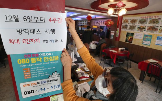오는 6일부터 수도권 사적모임 인원이 6명으로 제한된다. 3일 서울 동작구 대방동의 한 중식당에서 업주가 관련 안내문을 붙이고 있다. 연합뉴스