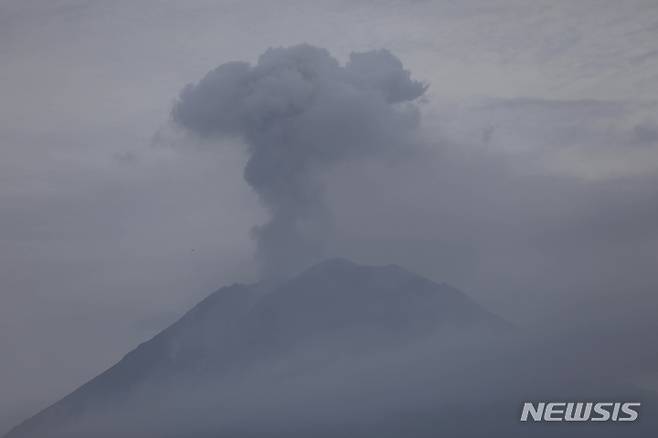 [자바(인도네시아)=AP/뉴시스]5일 인도네시아 자바섬 동부에 위치한 스메루 산이 분화하며 화산재를 분출하고 있다. 2021.12.05.