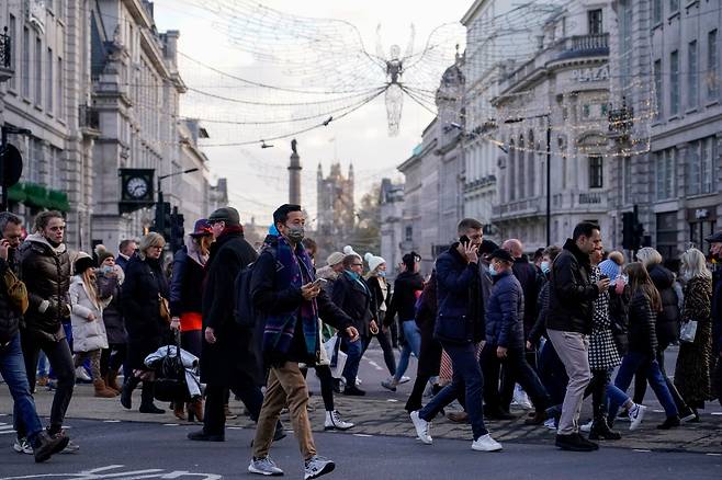 마스크를 쓰고 영국 런던 시내 중심가를 걸어가는 사람들의 모습.