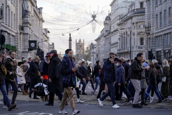 오미크론 변이 코로나 바이러스가 세계로 확산되고 있는 가운데 지난 4일(현지시간) 영국 런던 피카딜리 광장에서 시민들이 길을 건너고 있다.AP뉴시스