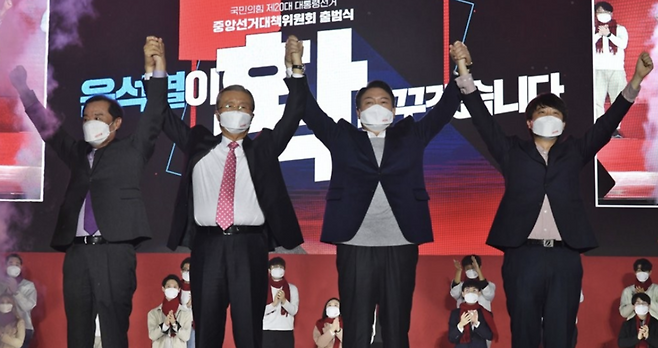 국민의힘 윤석열 대선 후보가 6일 오후 서울 송파구 올림픽공원 체조경기장에서 열린 국민의힘 제20대 대통령선거 선거대책위원회 출범식에서 김종인 총괄선대위원장, 이준석, 김병준 상임선대위원장과 손을 맞잡고 인사하고 있다. / 사진=연합뉴스