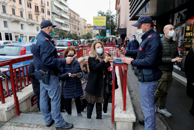 6일(현지시간) 이탈리아 수도 로마의 지하철 입구에서 경찰이 승객들의 신종 코로나바이러스 감염증(코로나19) 백신접종 증명서인 '그린 패스'를 확인하고 있다. 이탈리아에서는 이날부터 그린 패스가 없으면 지하철과 버스 등 대중교통과 음식점, 술집, 영화관 등 실내 시설에 출입할 수 없다./로이터연합뉴스