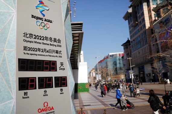 7일 중국 베이징에서 시민들이 2022년 베이징 동계올림픽 카운트다운을 알리는 시계 옆을 지나가고 있다.로이터뉴스1