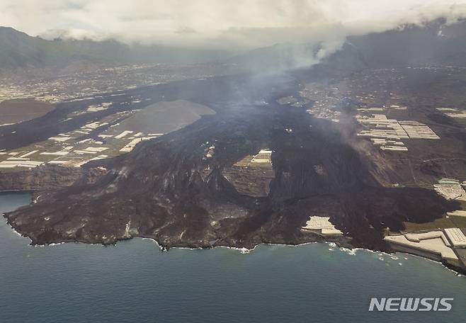 [라팔마=AP/뉴시스] 6일(현지시간) 스페인 카나리아제도 라팔마섬 화산에서 분출된 용암이 바다로 흘러들고 있다. 2021.12.08.