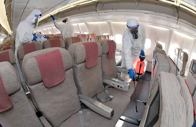 9일 인천국제공항 아시아나항공 격납고에서 관계자들이 A330 기내 방역소독을 하고 있다. 공동취재사진