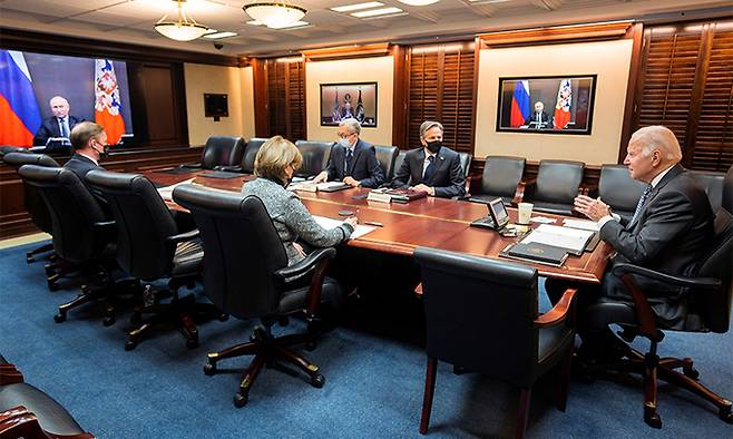 지난 7일(현지시간) 조 바이든 미국 대통령(오른쪽 끝)이 백악관 상황실에서 블라디미르 푸틴 러시아 대통령(화면 속)과 우크라이나 사태 해법 등 논의를 위한 화상 정상회담을 하고 있다. 워싱턴=AP연합뉴스