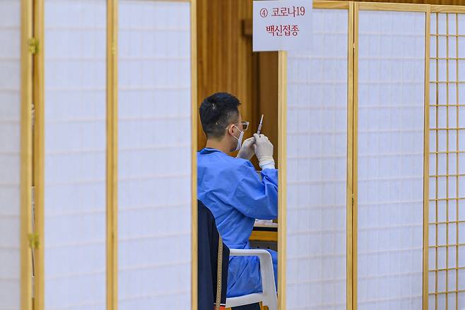 16일 오후 광주 광산구의 한 중학교 강당에서 '찾아가는 학교단위 백신접종'이 진행돼 의료진이 백신을 주사기로 옮겨 담고 있다./공동취재단