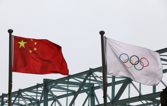 중국 베이징 올림픽위원회에 설치된 중국 국기인 오성홍기와 올림픽 깃발이 바람에 휘날리고 있다. 로이터 뉴스1