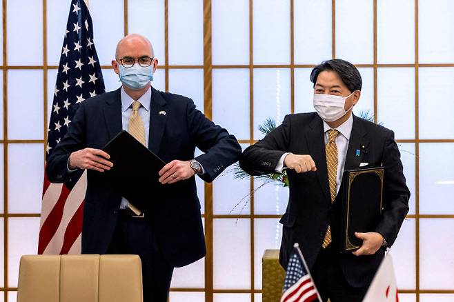 하야시 요시마사(오른쪽) 일본 외무상과 레이몬드 그린 주일 미국대사가 7일 도쿄 외무성에서 방위비분담특별협정(SMA)에 서명하는 자리에서 팔꿈치 인사를 하고 있다. (사진=로이터 제공)