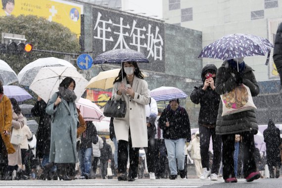 일본 도쿄에 폭설이 내린 지난 6일 시부야 스크램블 교차로 모습. 마스크를 쓴 사람들이 길을 건너고 있다. AP뉴시스