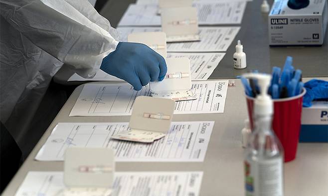 지난 6일(현지시간) 미국 캘리포니아주 롱비치의 신종 코로나바이러스 감염증(코로나19) 검사소에서 한 간호사가 신속항원검사 키트를 준비하고 있다. 롱비치=AP연합뉴스
