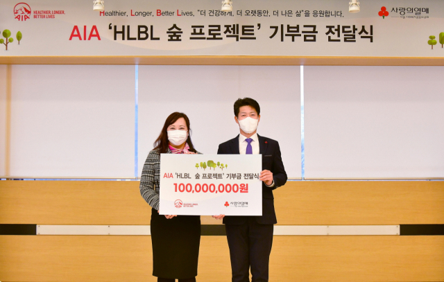 황지예(왼쪽) AIA생명 마케팅본부장이 지난 10일 김진곤 서울 사랑의 열매 사무처장에게 HLBL 숲 프로젝트을 위해 1억원을 기부하고 있다. /사진 제공=AIA생명