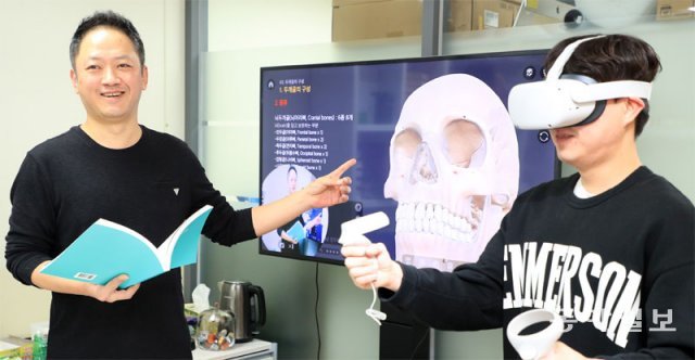 지난해 12월 31일 서울 노원구 인덕대에서 이철승 게임·VR디자인학과 교수(왼쪽)가 가상현실(VR) 기반 ‘구강해부학’ 콘텐츠를 시연해 보고 있다. 학생들은 VR 구현 기기(HMD)를 착용해 3D로 학습할 수 있다. 전영한 기자 scoopjyh@donga.com