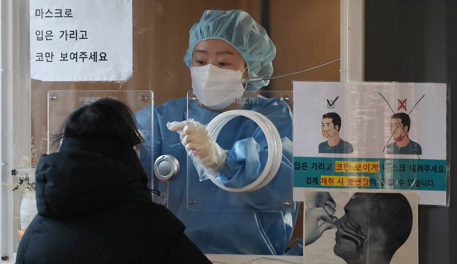 13일 오전 서울역 광장 중구 코로나19 임시 선별검사소에서 한 시민이 검사를 받고 있다. [연합]