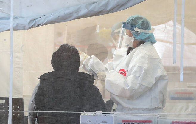 부산에서 오미크론 변이 바이러스의 지역 감염이 확산세를 보인 13일 오후 사상구보건소 선별진료소를 찾은 시민들이 신종 코로나바이러스 감염증(코로나19) 검사를 받고 있다.    연합뉴스