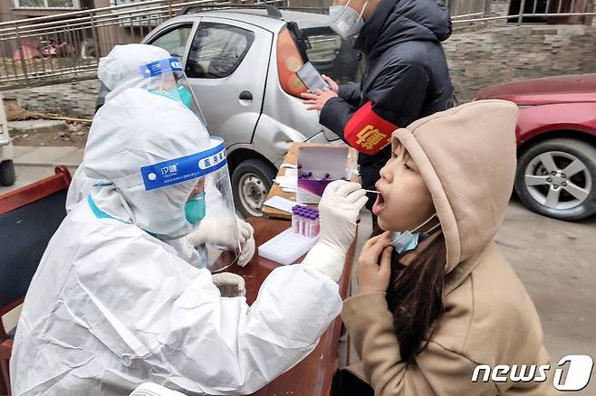 12일 중국 허난성 안양시에서 한 주민이 신종 코로나바이러스 감염증(코로나19) 핵산 검사를 받고 있다. 2022.01.12 © AFP=뉴스1