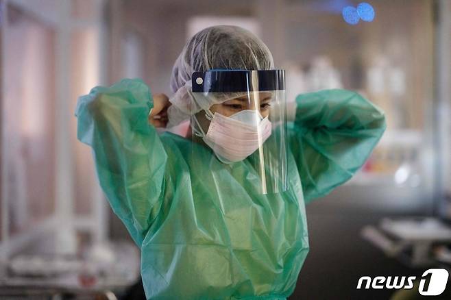 8일(현지시간) 일본 요코하마에 있는 성마리안나 대학병원에서 의료진이 코로나19 환자 음압병실에 들어가기 위해 방호복을 입고 있다. © AFP=뉴스1 © News1 우동명 기자
