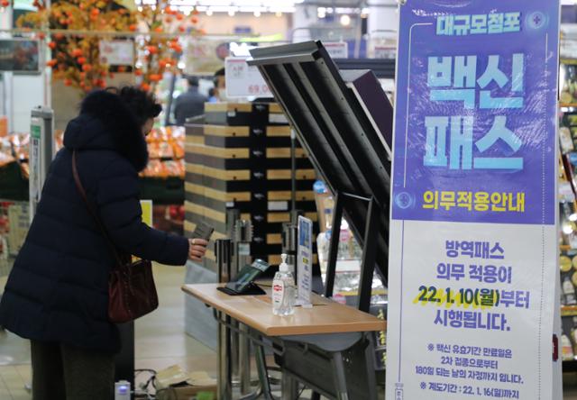 13일 오후 서울 시내 대형마트에서 시민들이 입장하기 위해 접종 증명을 하고 있다. 연합뉴스