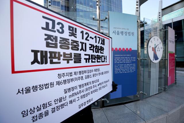 14일 오후 서울 서초구 서울행정법원 앞에서 한 학부모가 고3과 12~17세의 코로나19 백신 접종 중지를 각하한 재판부를 규탄하는 손팻말을 들고 1인 시위를 하고 있다. 뉴시스