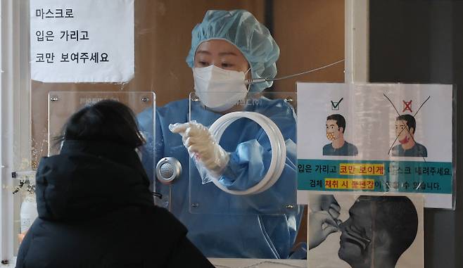 지난 13일 서울역 앞 코로나19 임시선별검사소에서 한 시민이 검사를 받고  있다. 연합뉴스