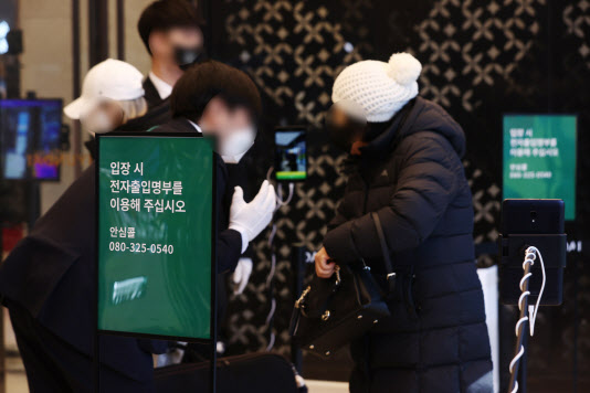 법원이 서울 내의 3천㎡ 이상 백화점·마트·상점에 대해 방역패스 효력 정지를 결정한 가운데 16일 서울의 한 백화점 입구에서 시민들이 QR코드 체크를 하고 있다. (사진=연합뉴스)