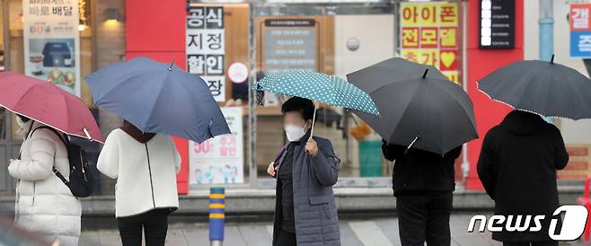 제주시 이도이동 한 거리에서 우산을 쓴 시민들이 발걸음을 옮기고 있다. 2021.1.26/뉴스1 © News1 오현지 기자