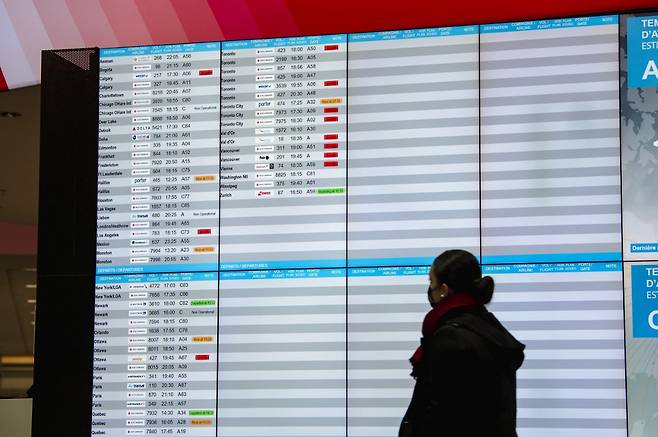 17일(현지시간) 캐나다 몬트리올 국제공항에서 한 여행객이 항공편 운항 현황 게시판을 살펴보고 있다. 전날부터 이날까지 미국 동부 연안에 내린 폭설로 미국에선 이틀 동안 4200편 이상의 항공편 운항이 취소됐다. /사진=AFP