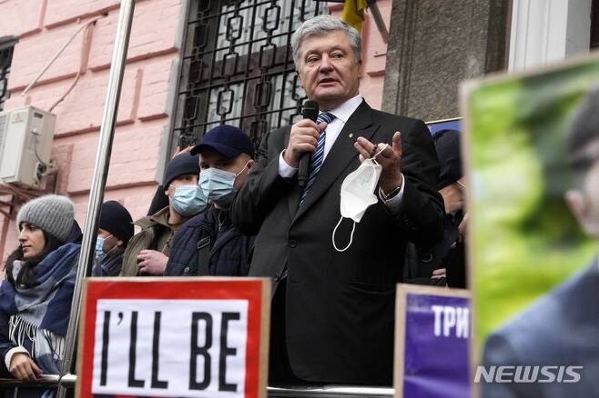 [키예프(우크라이나)=AP/뉴시스] 페트로 포로셴코 전 우크라이나 대통령이 키예프 법원 앞에서 지지자들을 향해 발언하고 있다. 2022.01.18.