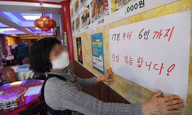 사적모임 허용인원이 6명으로 완화된 17일 서울 동작구 한 중식당에서 주인이 변경된 인원 기준 안내문을 붙이고 있다. 허정호 선임기자