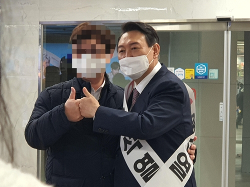 국민의힘 윤석열 대선 후보가 17일 저녁 서울 지하철 2호선 을지로입구역에서 퇴근길 인사를 하고 있다./연합뉴스