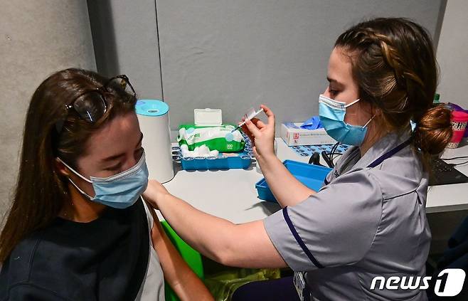 지난달 20일 (현지시간) 영국 리버풀의 병원에 마련된 코로나19 백신 접종소에서 공무원이 백신을 맞고 있다. © AFP=뉴스1 © News1 우동명 기자