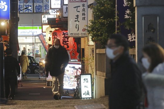 일본 도쿄에서 마스크를 쓴 사람들이 술집과 식당들이 들어선 거리를 걷고 있다. AP=연합뉴스