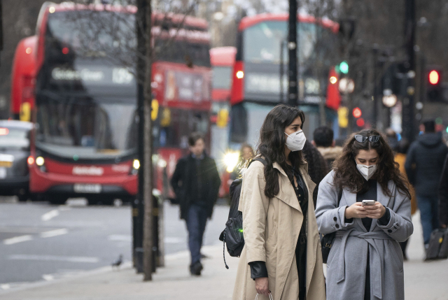 지난 10일(현지 시간) 영국 런던에서 마스크를 쓴 시민들이 길을 걸어가고 있다./AP연합뉴스